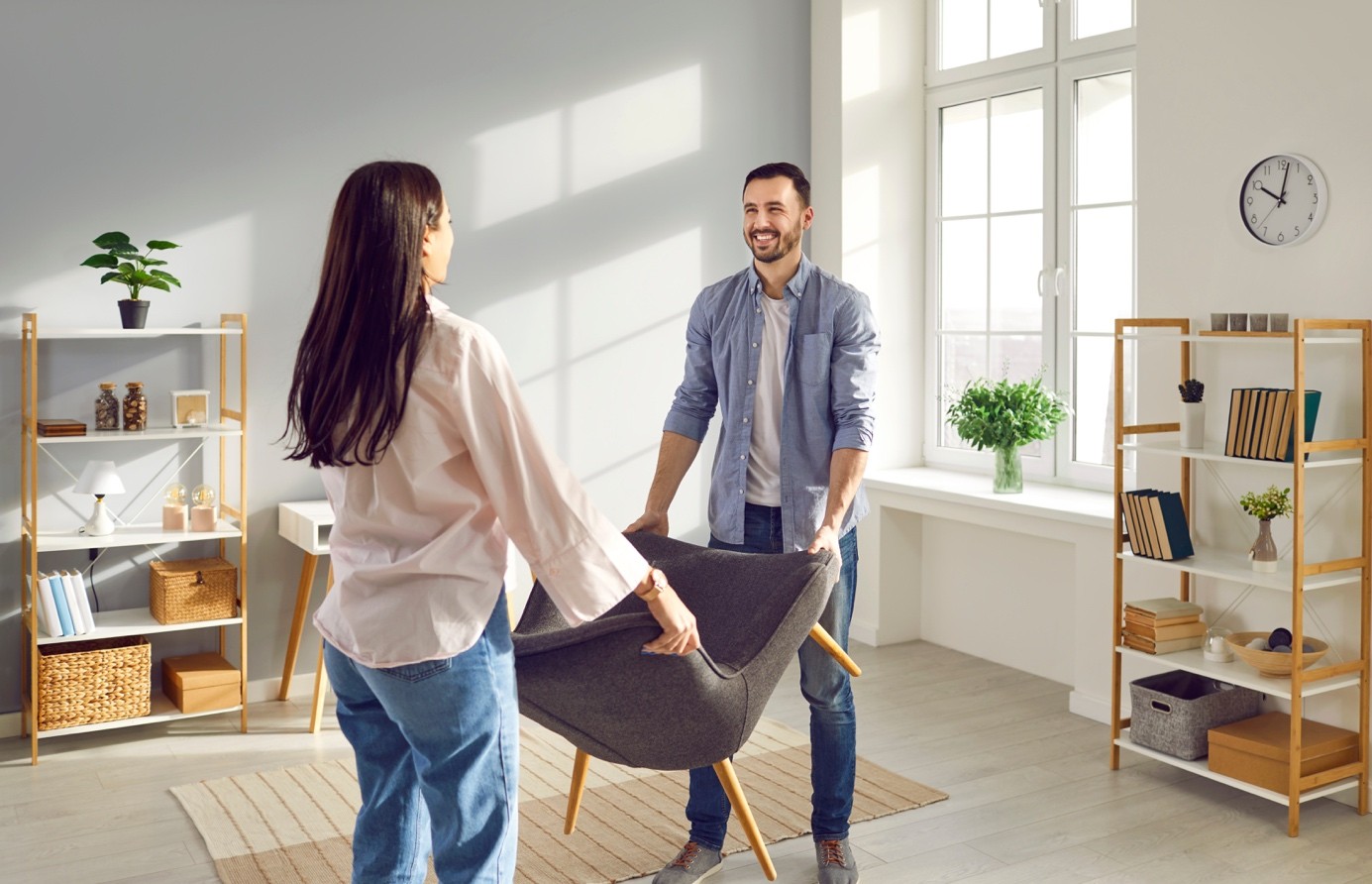 Happy couple carrying armchair into their living room -goodgardn.nl 